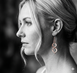 Close-up of a woman wearing a rcopper earring with a blurred background