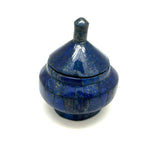 A blue lapis jar with a lid, against a white background.
