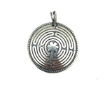 Silver pendant with intricate labrynth design on a white background