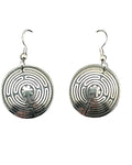 Pair of silver labyrinth earrings on a black card with a white background