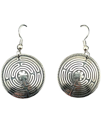 Pair of silver labyrinth earrings on a black card with a white background